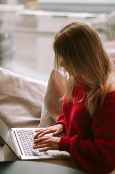 Photo of female student sitting on chair doing work on laptop.