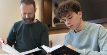 Father and son reading Bible together.