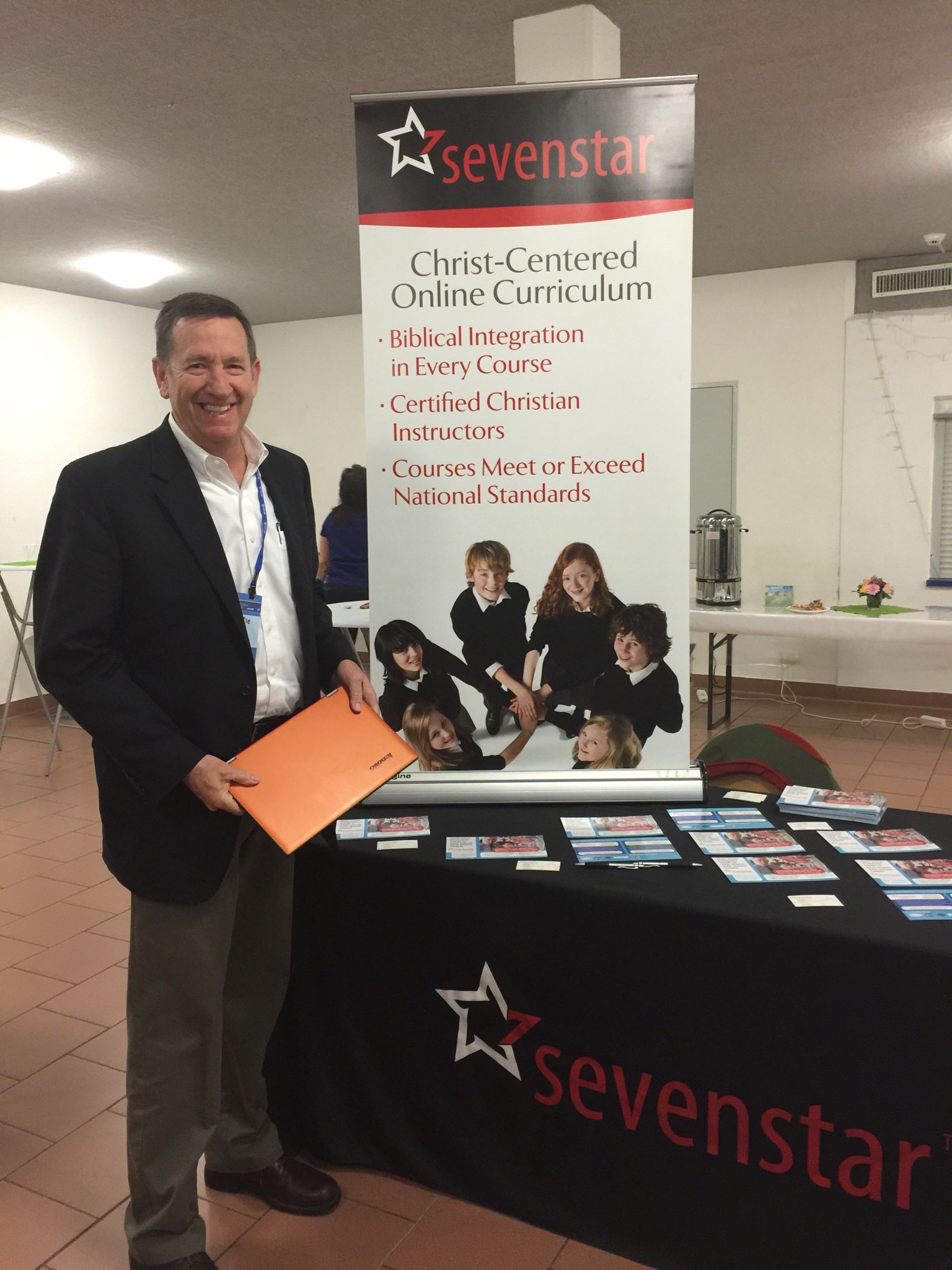 Founder Dr. Mark Beadle standing beside Sevenstar booth at conference.